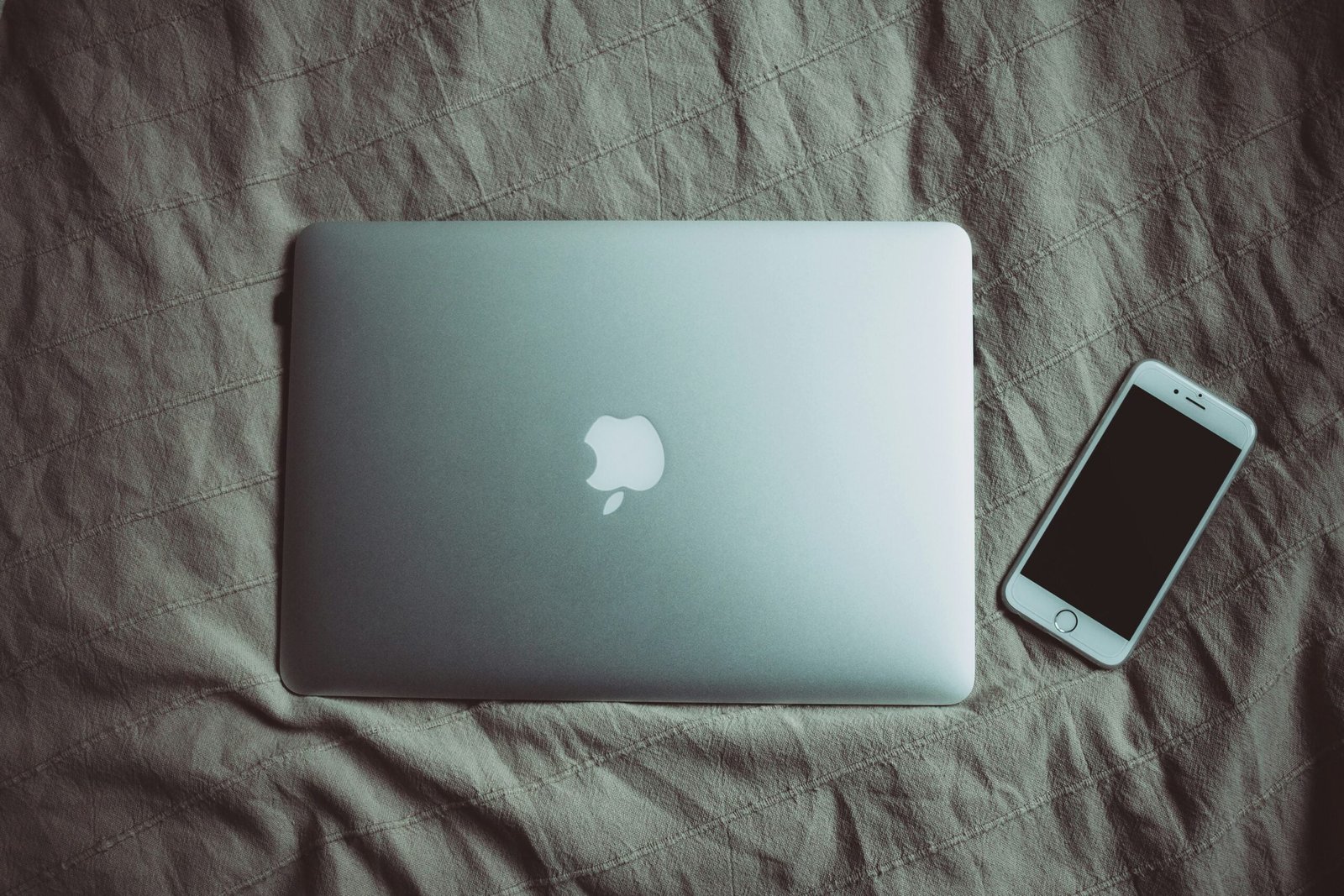 silver MacBook beside post-2014 iPhone